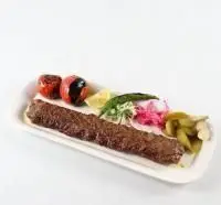 کباب کوبیده گوشت لذیذ باغچه رستوران ونوس شهران همراه با گوجه و فلفل کبابی، نان داغ و ترشیجات. غذای سنتی ایرانی.