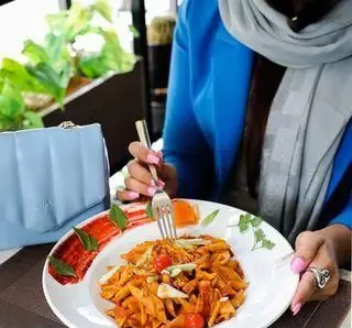 مشتری در حال لذت بردن از پاستای لذیذ و داغ در رستوران ایتالیایی ویند. تجربه‌ای به‌یادماندنی از غذای اصیل ایتالیایی.