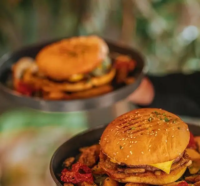 همبرگرهای خوشمزه و اشتهاآور کافه رستوران بابل با نان گریل شده، پنیر و سیب‌زمینی مخصوص، انتخابی عالی برای وعده غذایی شما.