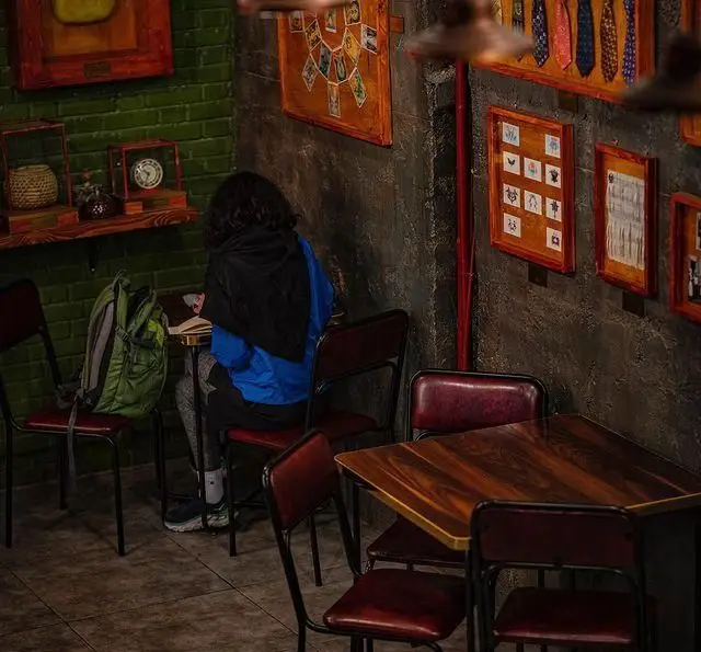 فضای دنج کافه رستوران بابل با دکوراسیون خاص و دانشجویی مشغول مطالعه در محیطی آرام و ایده‌آل برای کار و استراحت