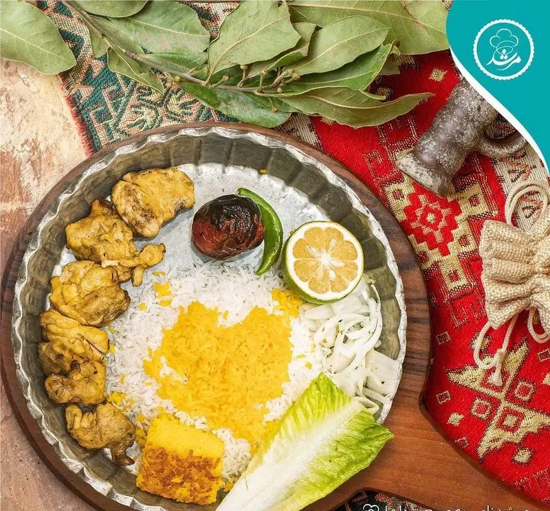 غذای خوشمزه و سنتی رستوران مرشد سعادت آباد شامل جوجه کباب، برنج زعفرانی، گوجه کبابی و لیمو تازه، تجربه‌ای اصیل از طعم‌های ایرانی.