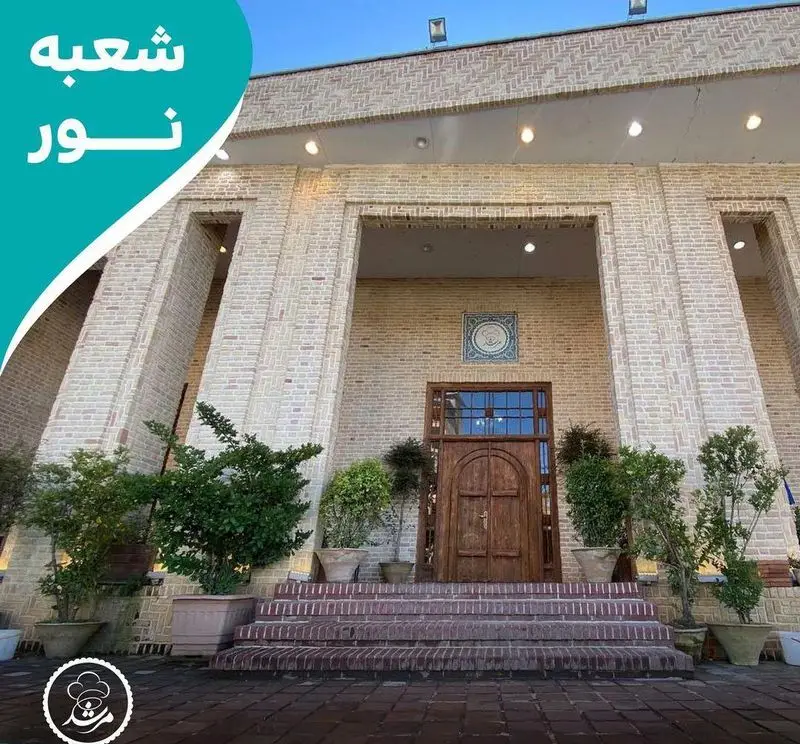 تصویر نمای خارجی رستوران مرشد سعادت آباد با معماری آجری جذاب، ورودی پله‌دار و درب چوبی نفیس. شعبه نور.