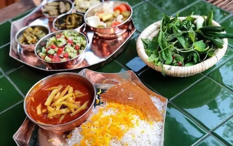 غذای اصیل ایرانی در رستوران رافی: خورشت قیمه با سیب‌زمینی، پلو زعفرانی و ته دیگ، به همراه سالاد شیرازی، سبزی و ترشی.