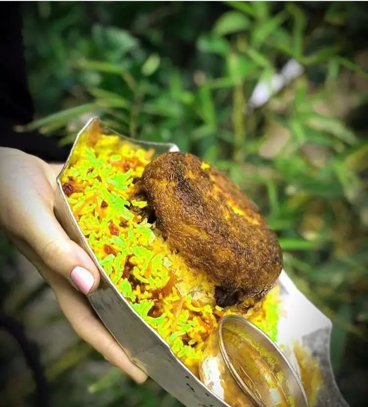 غذای خوشمزه رستوران رافی: چلو زعفرانی با زرشک و پسته، به همراه یک تکه مرغ یا کباب، سرو در ظرف شیک. تجربه طعم اصیل ایرانی.