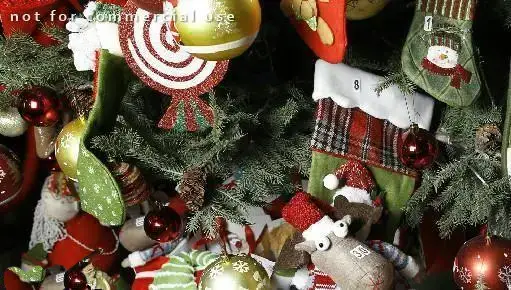 درخت کریسمس مزین به گوی‌های قرمز و طلایی و جوراب‌های جشن، نشانگر فضای دلپذیر و تعطیلات در رستوران منهتن گریل.