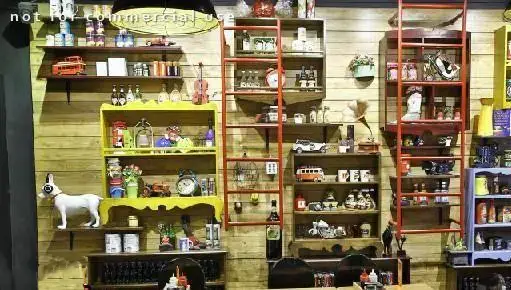 دکوراسیون داخلی رستوران منهتن گریل با قفسه‌های چوبی پر از اشیاء تزئینی و وینتیج، فضایی گرم و نوستالژیک برای مشتریان.