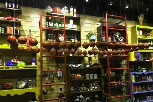 دکوراسیون داخلی و چیدمان منحصر به فرد رستوران منهتن گریل: قفسه‌های چوبی با کالاهای دکوری، ساعت‌ها و تزئینات آویز.