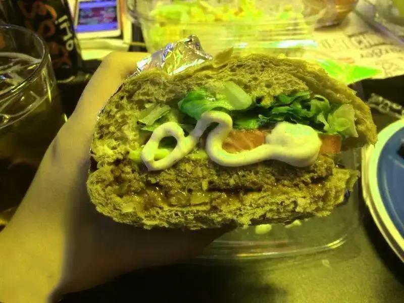 ساندویچ تازه و لذیذ رستوران منهتن گریل با نان سبوس‌دار، پر از کاهو، گوجه فرنگی، سس مخصوص و مخلفات گوشتی.