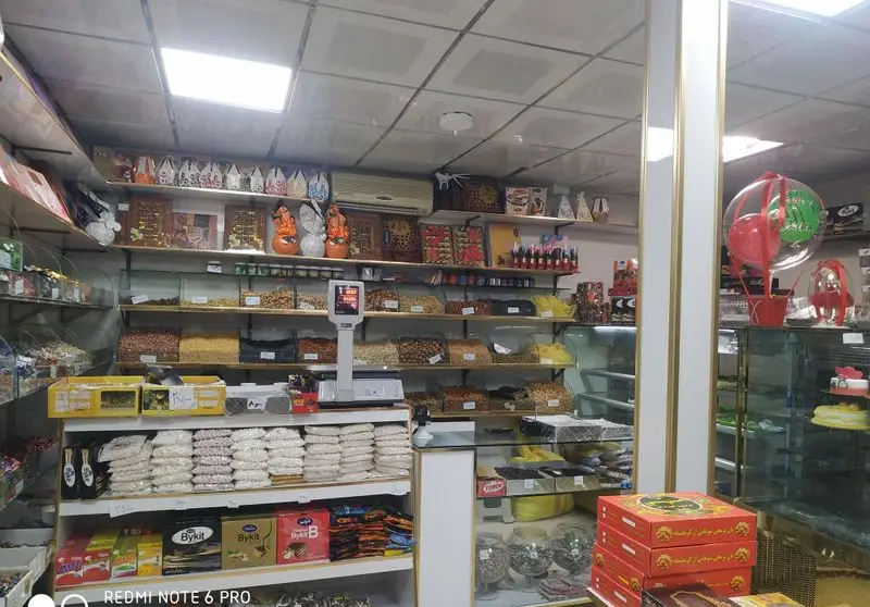 تصویر داخلی قنادی گل (مجید) با طیف وسیعی از آجیل، خشکبار، شیرینی، شکلات، کیک و دسرهای متنوع و تازه برای فروش.