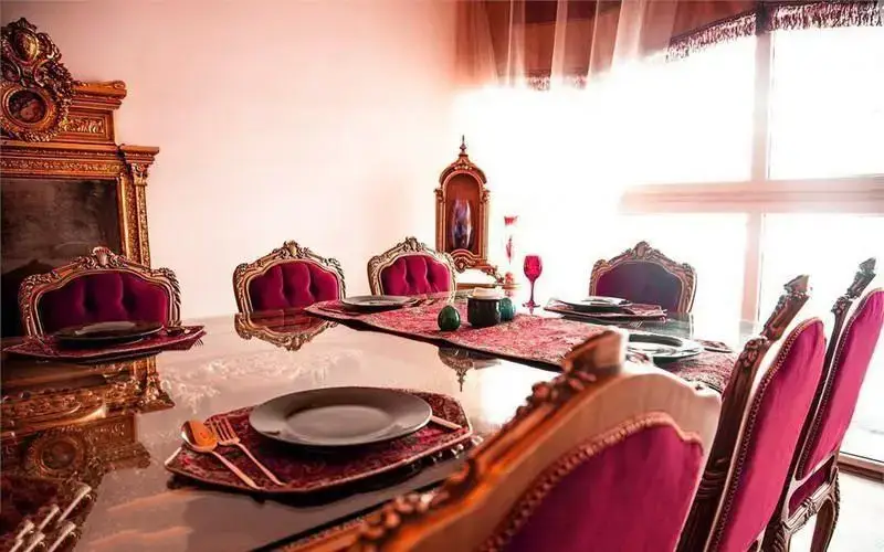 میز غذاخوری بزرگ و لوکس رستوران رزفر با صندلی‌های طلایی و مخمل زرشکی، چیدمان زیبا و دکوراسیون داخلی مجلل برای مهمانان.