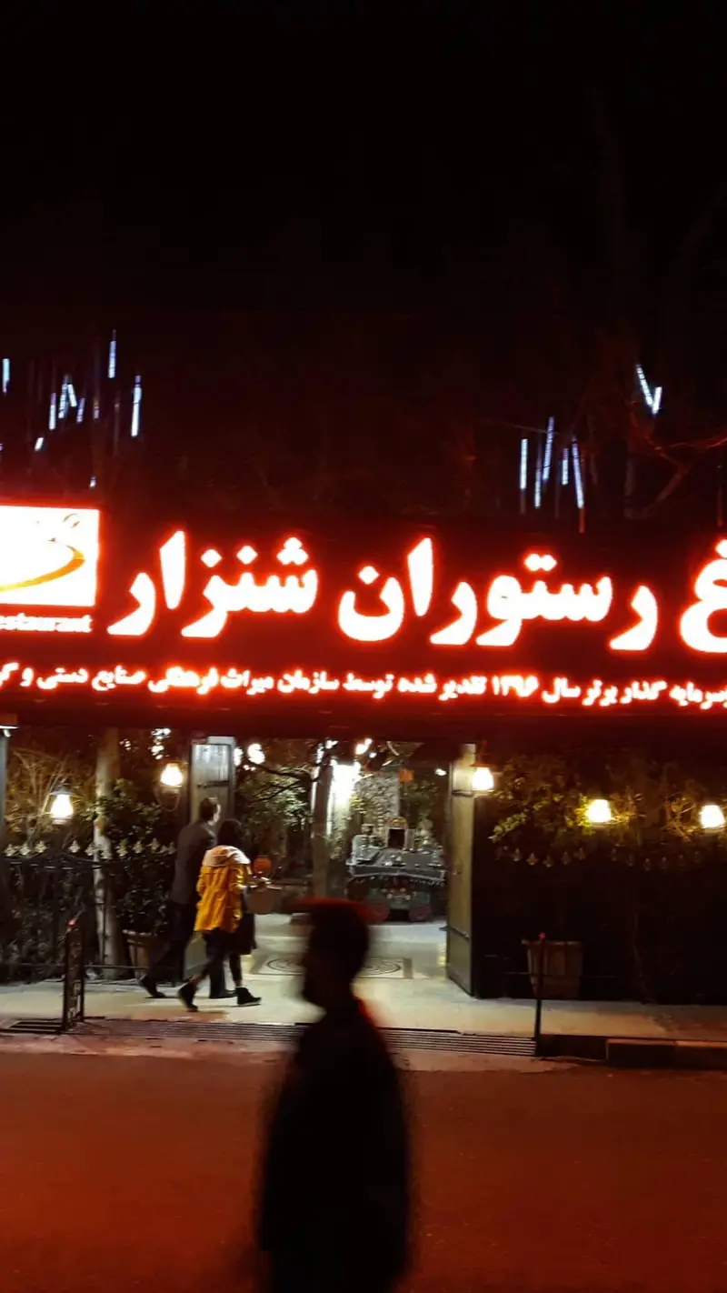 نمایی جذاب در شب از تابلوی نئون رستوران شنزار، با نورپردازی گرم و ورودی دلنشین آماده پذیرایی از میهمانان.