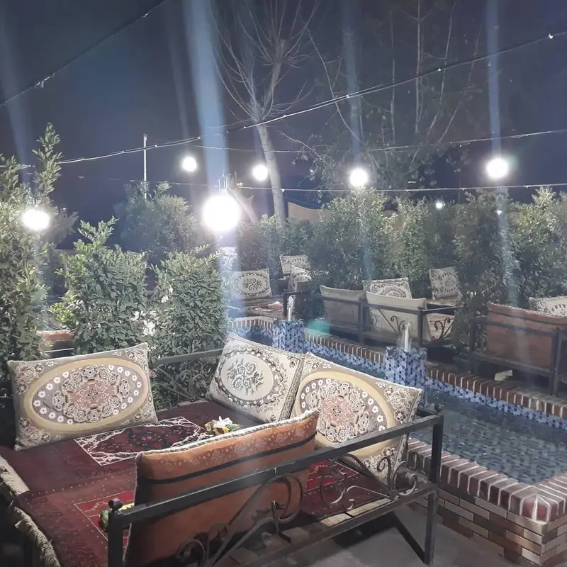 فضای دلنشین و سنتی رستوران شنزار در شب با نورپردازی زیبا، مناسب برای دورهمی‌های خانوادگی و دوستانه در محیطی آرام و سرسبز