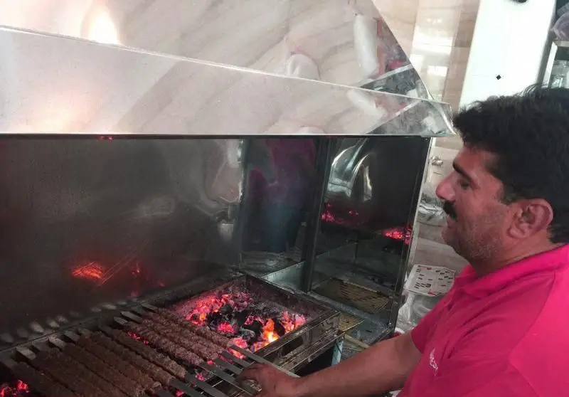 تصویری از پخت کباب کوبیده ذغالی اصیل در کباب سرای محسن توسط استاد کار ماهر، آماده برای سرو غذای خوشمزه و با کیفیت.