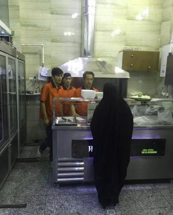 محیط داخلی کباب سرای محسن با کارکنان آماده ارائه سرویس و مشتری در حال سفارش غذا، فضای مناسب برای تجربه طعم کباب اصیل.