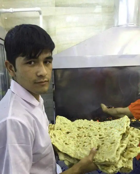 پرسنل کباب سرای محسن با نان‌های تازه و داغ در کنار منقل کباب، آماده ارائه بهترین طعم‌های ایرانی به مشتریان عزیز.