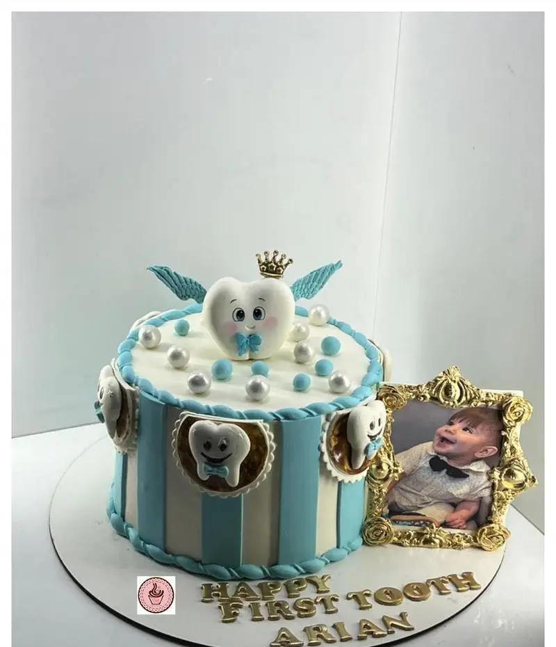 کیک دندونی پسرانه آبی و سفید شیرینی مانلی تهرانپارس، تم دندان با تاج و مروارید برای جشن اولین دندان کودک آریان.