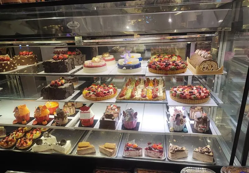 ویترین جذاب شیرینی مانلی تهرانپارس با انواع کیک‌های تازه، تارت‌های میوه‌ای و دسرهای خاص. بهترین کیفیت و تنوع را تجربه کنید.