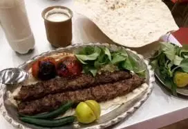 کباب کوبیده لذیذ جگرکی شبزدگان با نان داغ، گوجه کبابی، سبزی تازه و دوغ محلی. بهترین غذای ایرانی در رستوران شبزدگان.