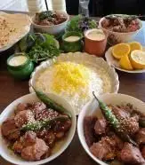 میز پر از غذاهای لذیذ جگرکی شبزدگان: انواع کباب و جگر تازه، برنج زعفرانی، نان داغ، سبزی و دوغ محلی. لذت طعم اصیل.