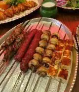 کباب‌های اشتهاآور و لذیذ جگرکی شبزدگان: سیخ‌های جگر، سوسیس، قارچ و پنیر کبابی تازه روی سینی پذیرایی.