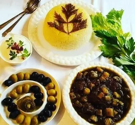 غذای سنتی ایرانی در رستوران خاتون‌ها: پلو زعفرانی قالبی با تزئین، خورشت کرفس خوشمزه، زیتون و ماست تزئین شده.