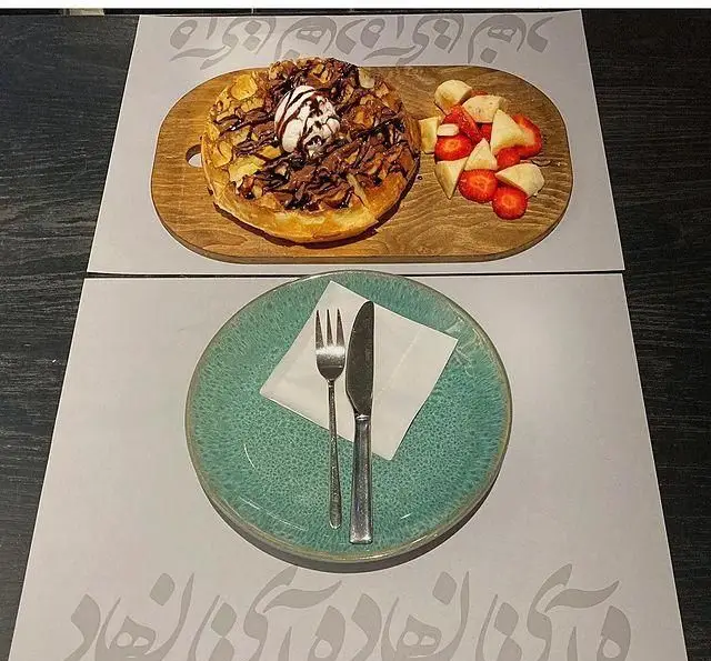 وافل لذیذ با سس شکلات، آجیل، بستنی و میوه‌ تازه، ایده‌آل برای صبحانه و دسر در کافه کتاب آینده.
