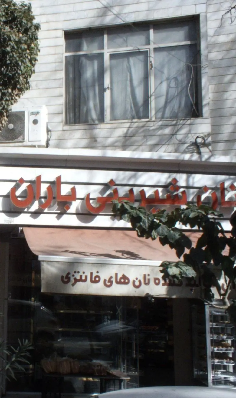 نمای بیرونی و تابلو نان شیرینی باران، فروشگاه تخصصی نان‌های فانتزی و شیرینی تازه با ویترین محصولات اشتهاآور.