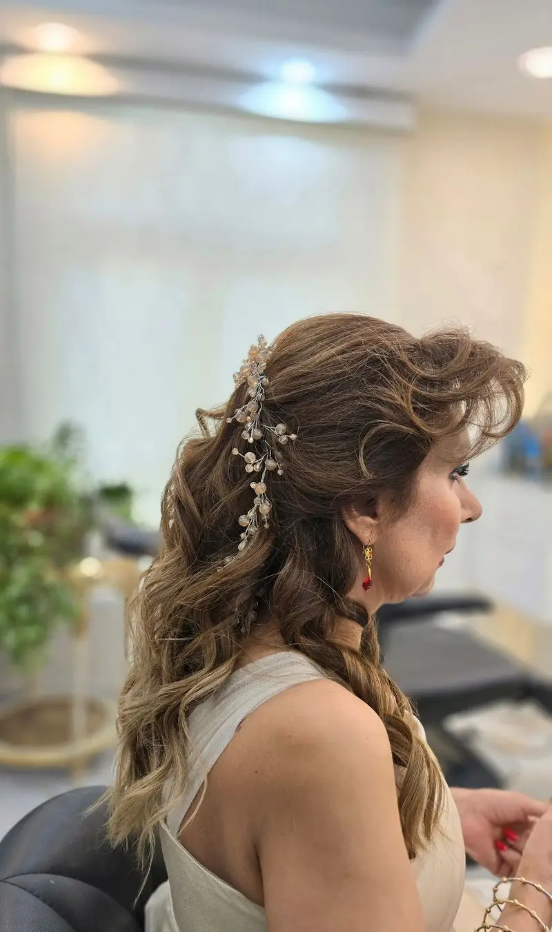 مدل شینیون موی نیمه باز مجلسی و شیک زنانه همراه با اکسسوری ریسه مرواریدی درخشان مناسب برای موهای بلند در سالن زیبایی