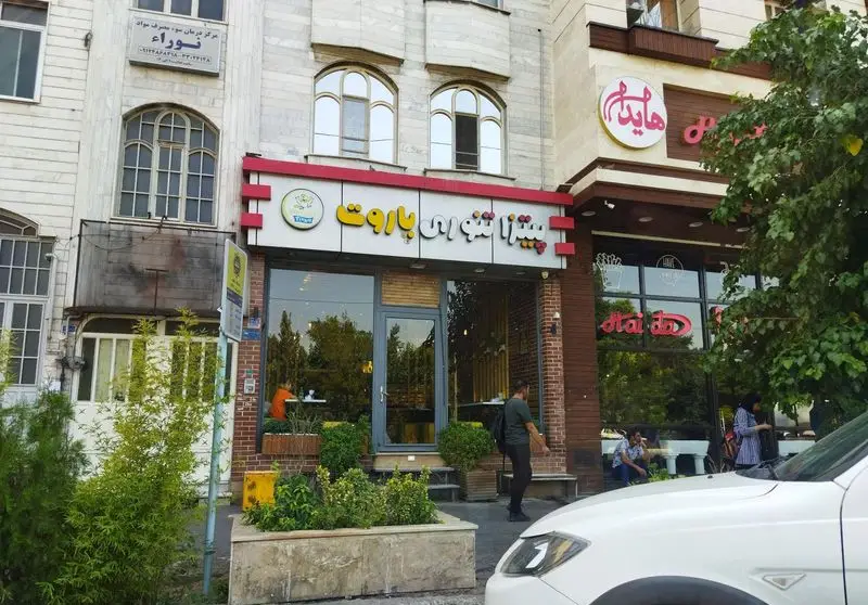 نمای بیرونی پیتزا تنوری پاروت، یک فست فود در تهران با ورودی شیشه‌ای و تابلو روشن، در کنار رستوران هایدم.