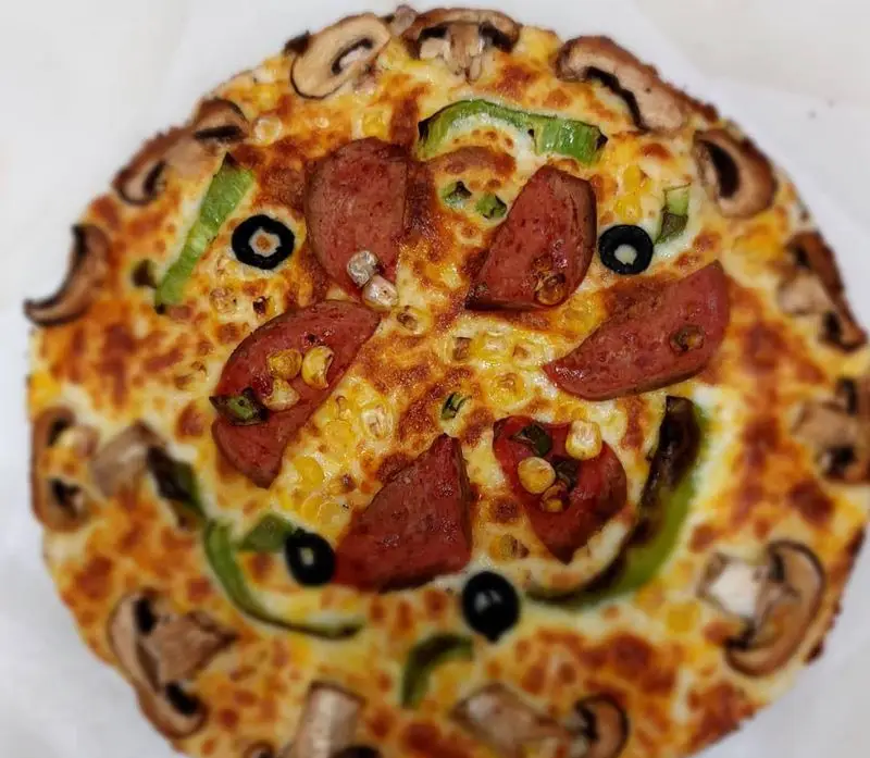 پیتزا بچه محل با پنیر فراوان، پپرونی، قارچ، فلفل دلمه، ذرت و زیتون. یک غذای خوشمزه و داغ برای سفارش آنلاین. طعم لذیذ!