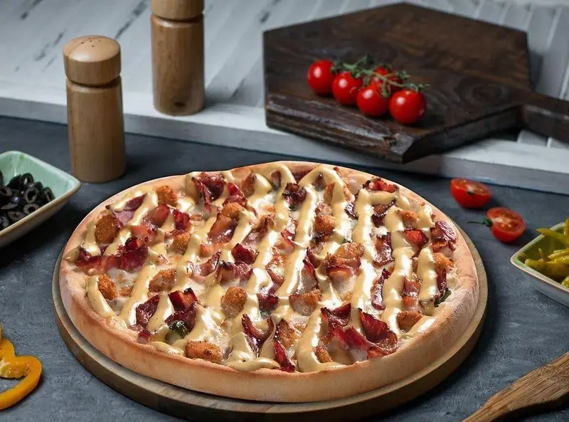 پیتزا مخصوص تله پیتزا شعبه پیروزی با سس ویژه و بیکن خوشرنگ، مناسب سفارش آنلاین و حضوری در رستوران فست فود