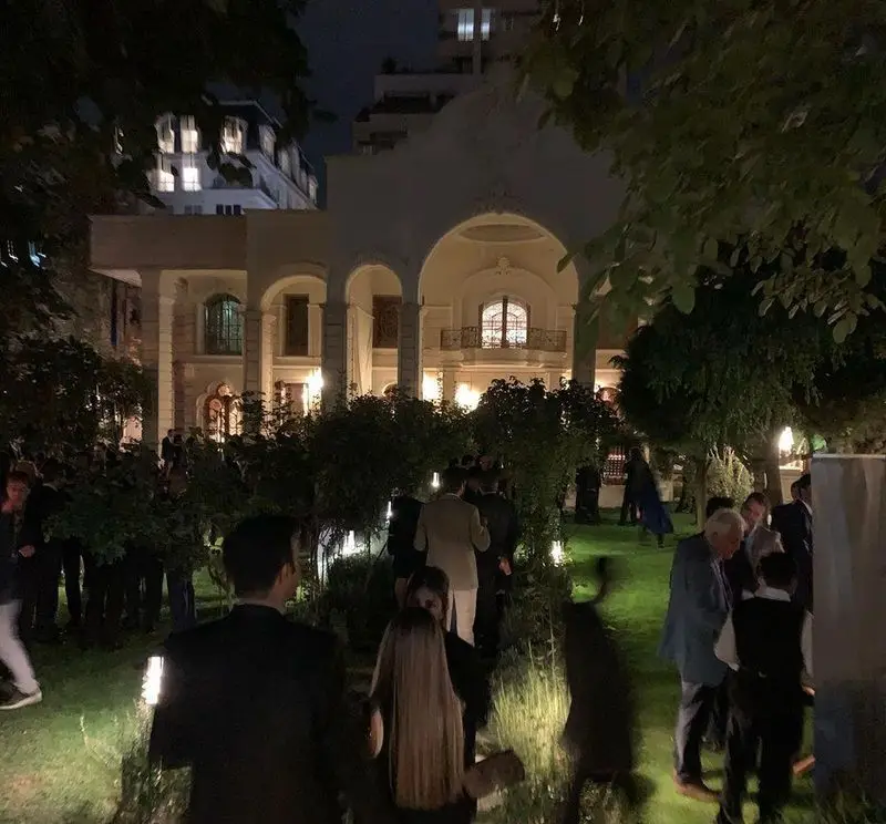 تصویر شبی مجلل و پرجنب و جوش در باغ یک عمارت باشکوه در تهران، مرتبط با گردهمایی‌های خاص تله پیتزا شعبه پیروزی.