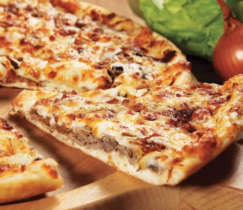 پیتزا گوشت و قارچ داغ و پنیری تله پیتزا (شعبه‌ی پیروزی) با نان طلایی و تکه‌های برش خورده، آماده برای سفارش آنلاین.