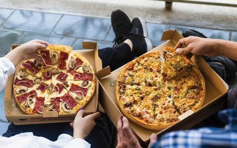 تجربه پیتزای عالی با تله پیتزا، شعبه پیروزی. دو نفر در حال انتخاب و لذت بردن از دو نوع پیتزای تازه و خوشمزه در جعبه.