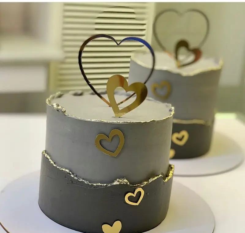 کیک تولد دو طبقه خاکستری طلایی لوکس با تاپر و قلب‌های دیواره، طراحی خاص و مدرن از شیرینی سرای شکلات تهرانپارس.