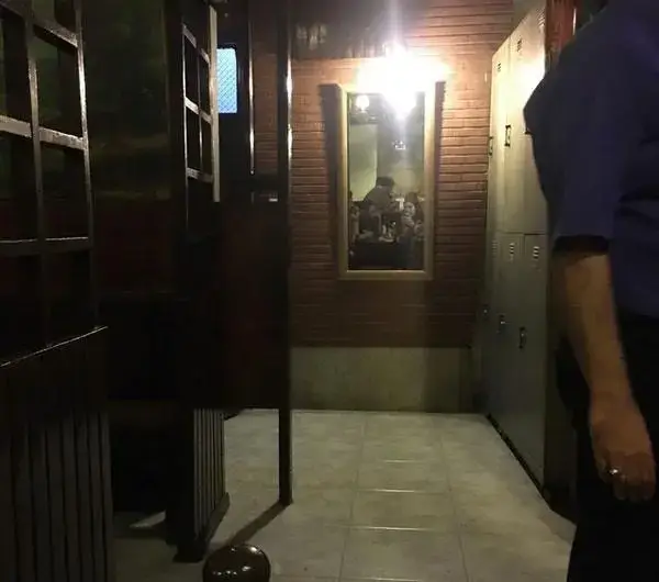 فضای داخلی رستوران پیتزا پنتری با پارتیشن‌های چوبی، دیوار آجری و آینه‌ای که مشتریان را در حال صرف غذا نشان می‌دهد.