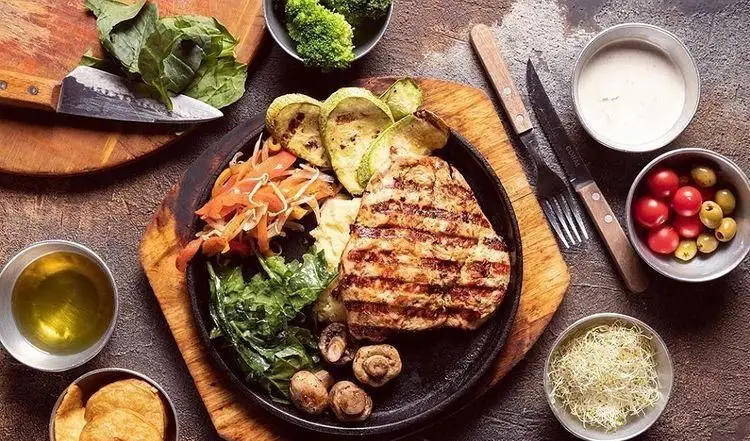 یک بشقاب کامل استیک گریل با کدو، سبزیجات تازه، سیب زمینی و قارچ، همراه با انواع ساید در فست فود شیکاگو گریل.