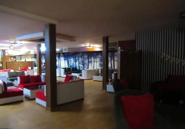 تصویری از فضای لژ و نشیمن کافه رستوران کمند با مبل‌های قرمز و سفید، دکوراسیون جذاب و محیطی دنج برای دورهمی‌ها.