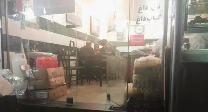 تصویری از نمای جلوی کبابی کبابسرای نیک با مشتریان در حال لذت بردن از کباب داغ و نان تازه در فضایی دلنشین.