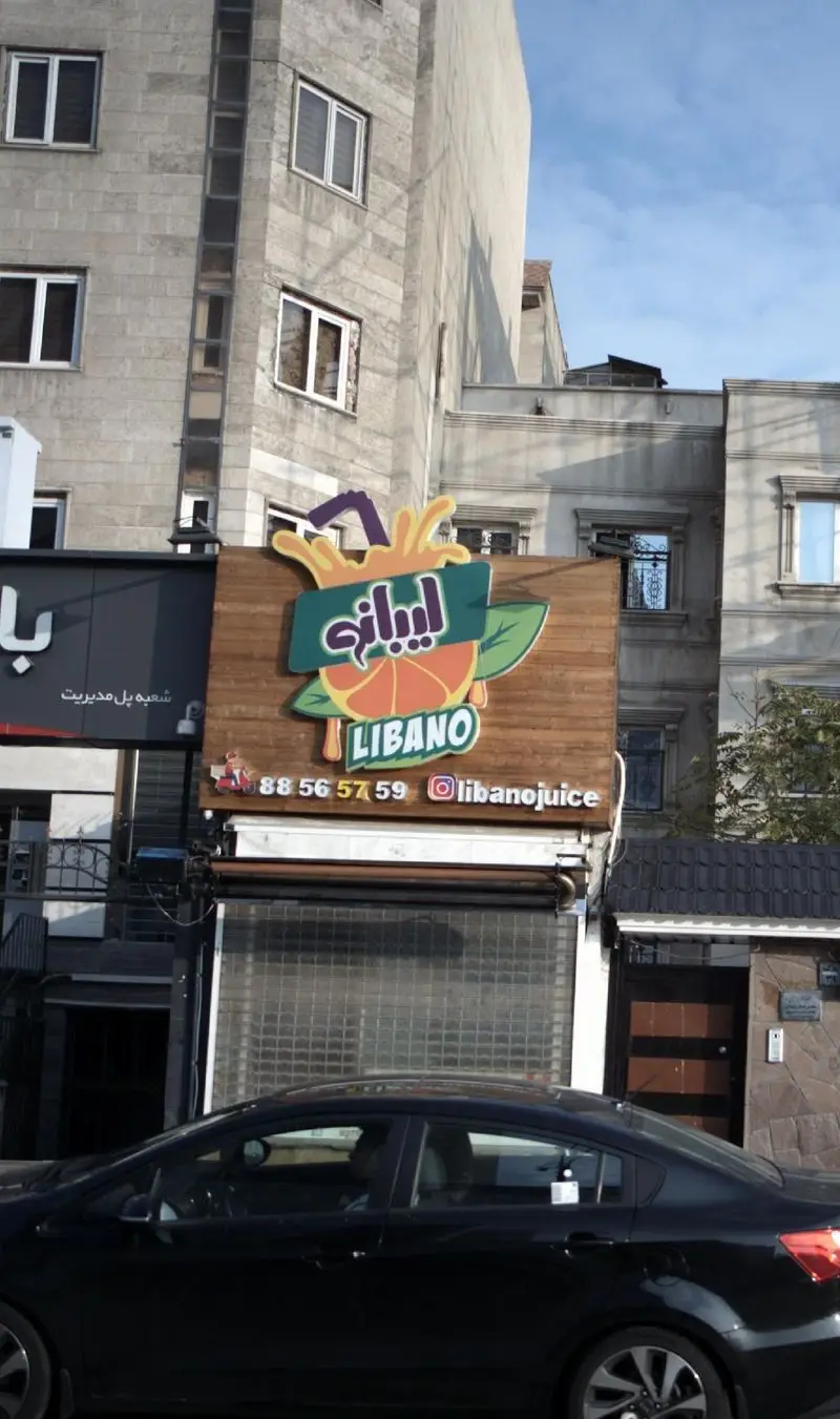 کسب و کار لیبانو: تابلوی آبمیوه‌فروشی با طراحی پرتقال، نام LIBANO. شماره تماس 88565759 و آیدی اینستاگرام libanojuice.