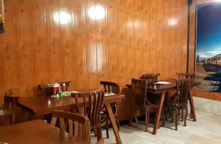 تصویری از فضای داخلی دلنشین و دکوراسیون چوبی رستوران پیتزا متری مهتاب با میز و صندلی‌های شیک برای تجربه‌ای لذت‌بخش.