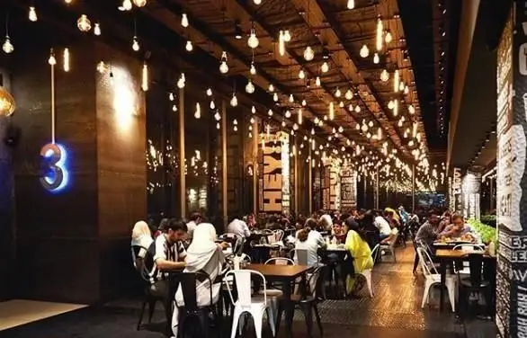 فضای دلنشین و شلوغ فست فود برگرلند؛ طراحی مدرن با صدها لامپ آویز، میزهای پر از مشتریان و اتمسفر گرم برای صرف برگر.