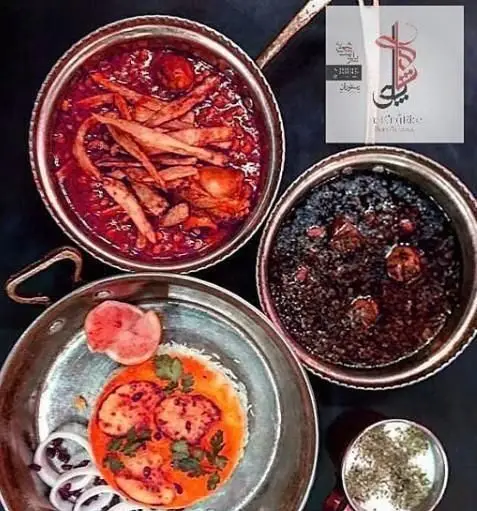 سفره مجلل رستوران ایرانی پلو شاهی نیوان شامل انواع خورشت، پلو، ته دیگ زعفرانی و ماست و خیار. غذای اصیل ایرانی.