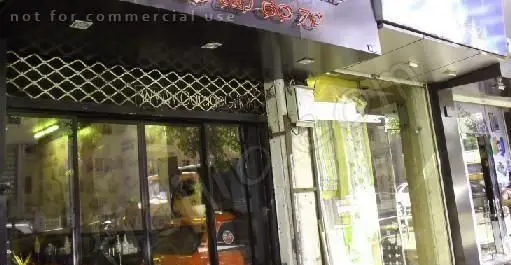 نمای بیرونی کسب و کار گاراژ گریل در شب، با کرکره مشبک فلزی و نورپردازی گرم داخلی. رستورانی برای فست فود و غذاهای گریل.