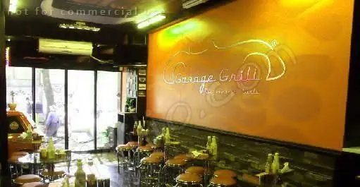 فضای داخلی دلپذیر رستوران و کافه گاراژ گریل، با صندلی‌های راحت و طراحی مدرن، مناسب برای تجربه لذیذترین گریل‌ها و نوشیدنی‌ها.