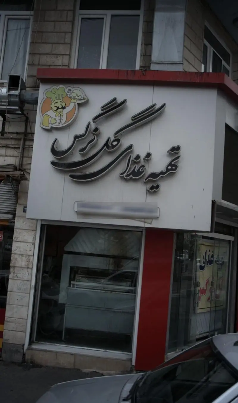 تصویر نمای بیرونی تهیه غذای گل نرگس با تابلوی برجسته، لوگوی سرآشپز و مرغ بریان، بهترین کترینگ غذای ایرانی و خانگی.