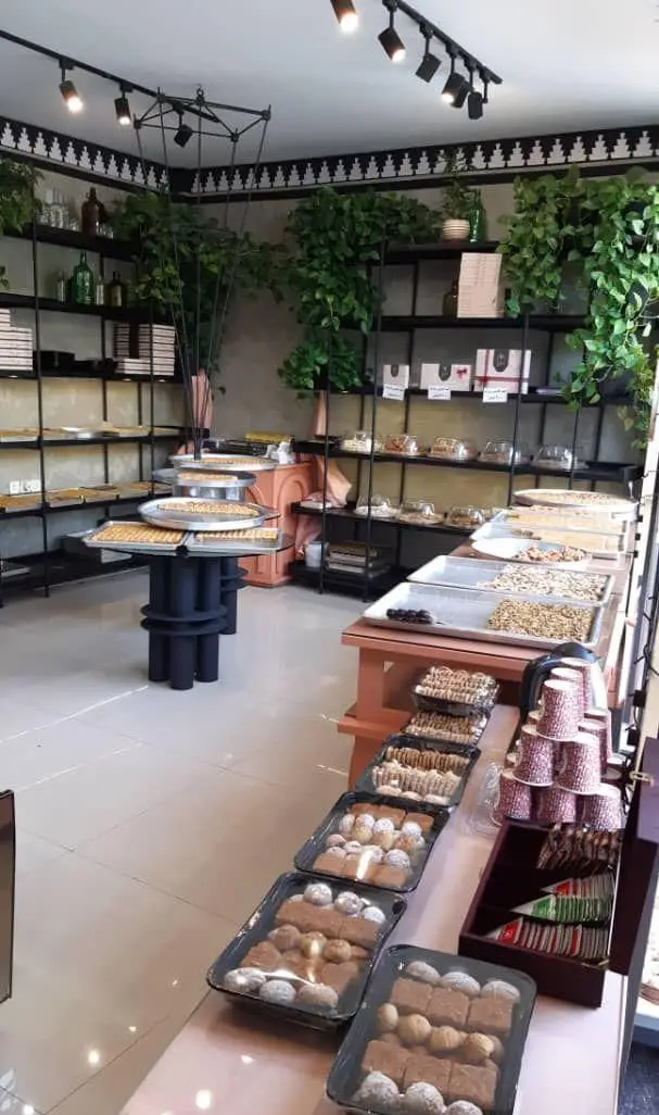 تصویری جذاب از فروشگاه شیرینی لبنانی لیالی، با چیدمان هنرمندانه انواع شیرینی تازه، کوکی‌ها و آجیل در محیطی مدرن و روشن.