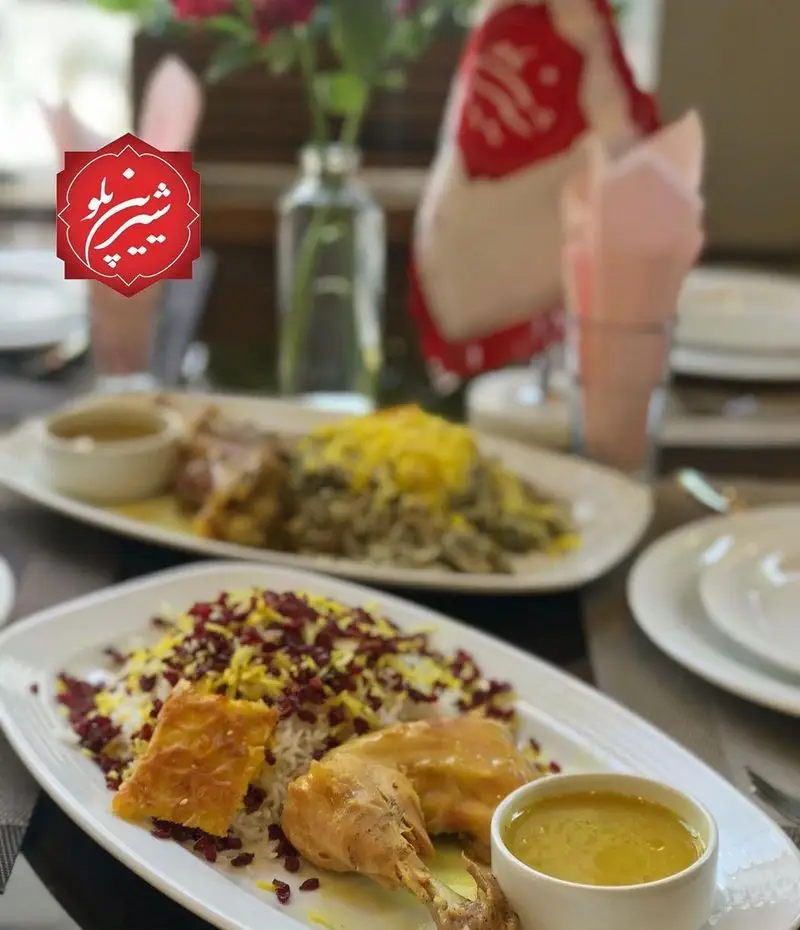 بشقاب غذای زرشک پلو با مرغ و ته دیگ زعفرانی در رستوران شیرین پلو، به همراه یک کاسه سس، آماده سرو. غذایی سنتی و اشتهاآور.