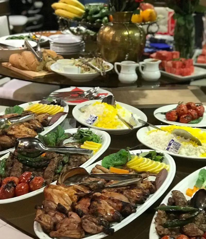 میز بوفه دلپذیر رستوران شیرین پلو با انواع کباب، جوجه، برنج زعفرانی، گوجه کبابی و سالاد. بهترین تجربه غذای ایرانی.