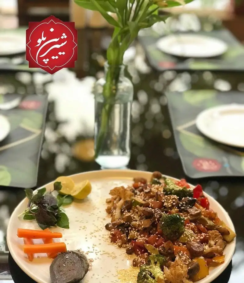 بشقاب سبزیجات تازه و خوش‌طعم رستوران شیرین پلو شامل بروکلی، قارچ و هویج با تزئین کنجد؛ وعده‌ای سالم و لذیذ.